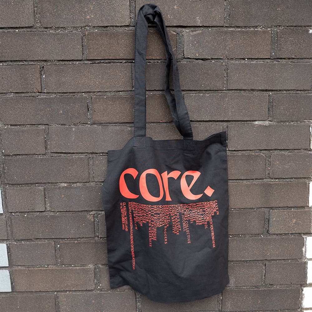 Black Core tote bag with a red Core logo and artist names